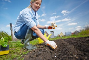 Image of female farmer sowing seed in the garden